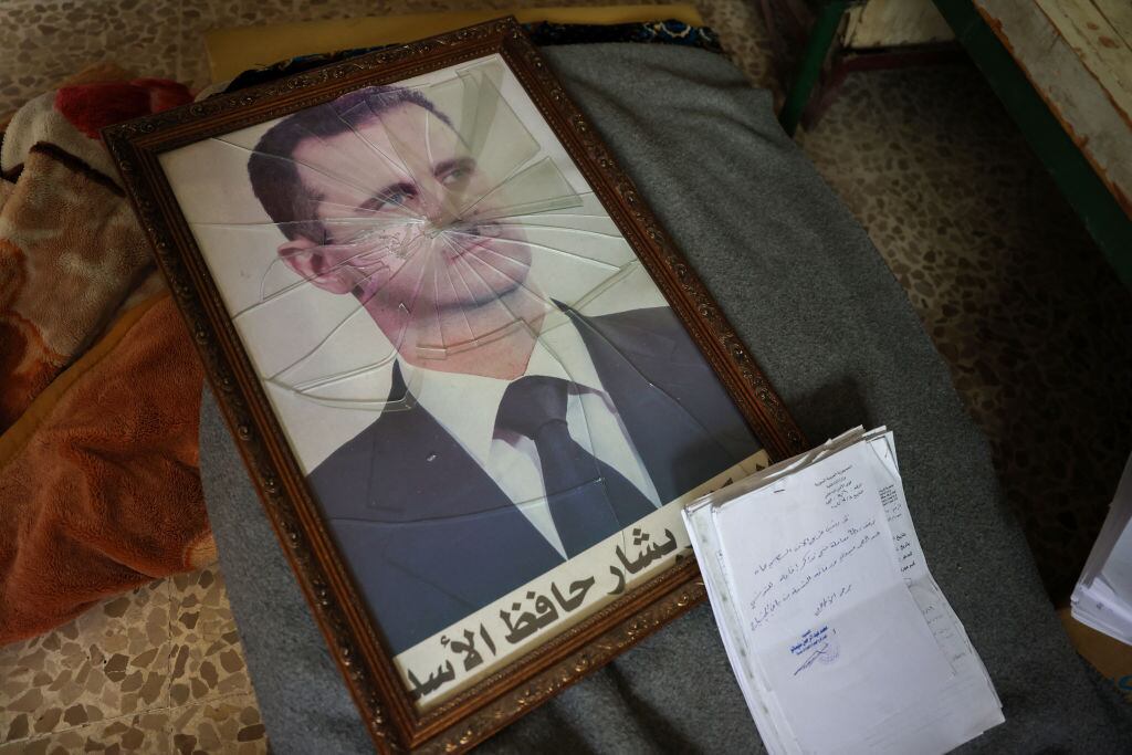 En retrato del presidente de Siria, Bashar Al Asad, queda roto en el suelo tras la llegada de los rebeldes yihadistas a la ciudad de Homs