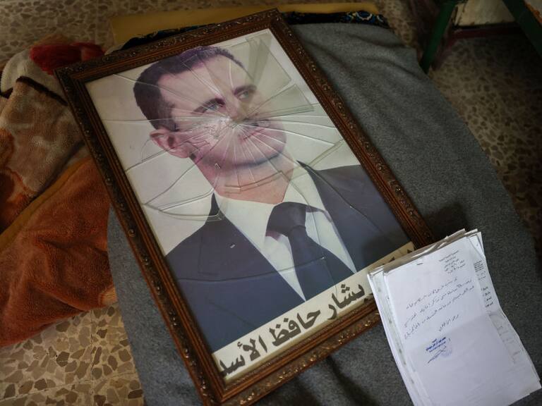 En retrato del presidente de Siria, Bashar Al Asad, queda roto en el suelo tras la llegada de los rebeldes yihadistas a la ciudad de Homs