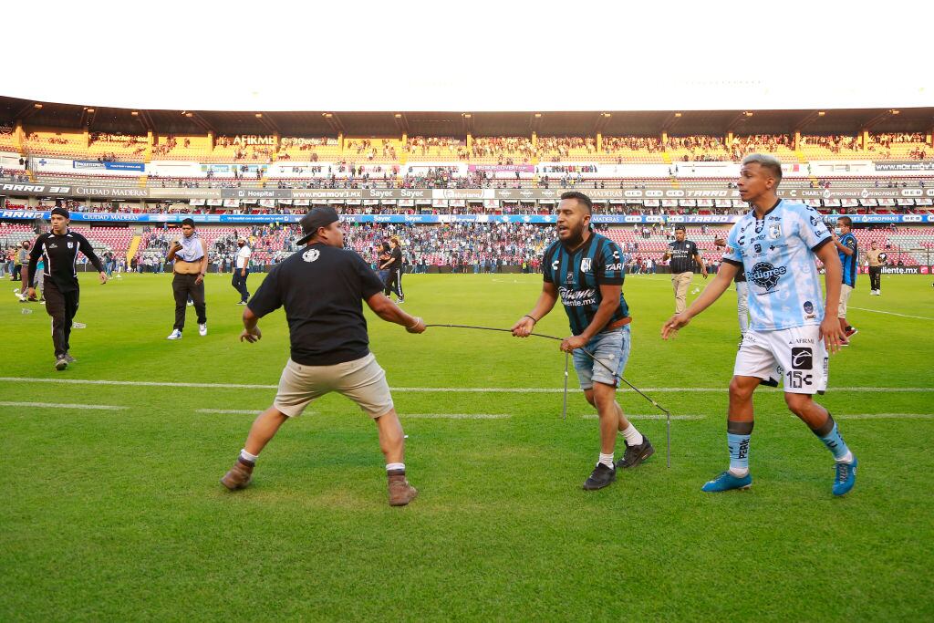 Barristas de Querétaro y Atlas se enfrentan en la cancha del estadio La Corregidora