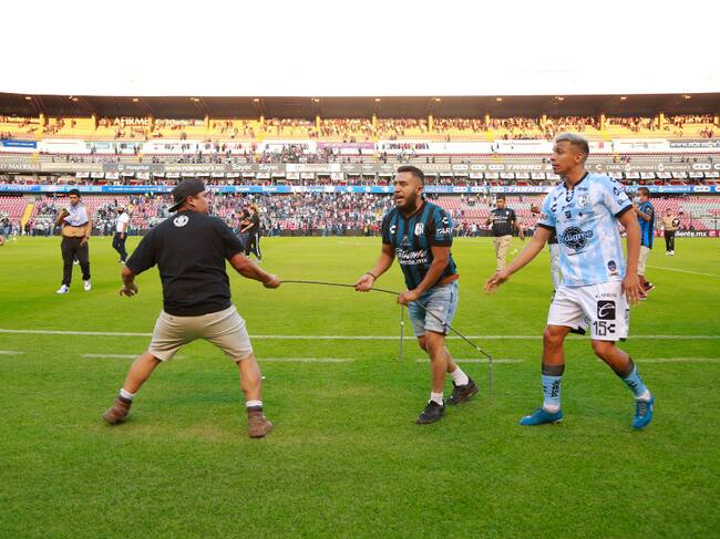 Barristas de Querétaro y Atlas se enfrentan en la cancha del estadio La Corregidora