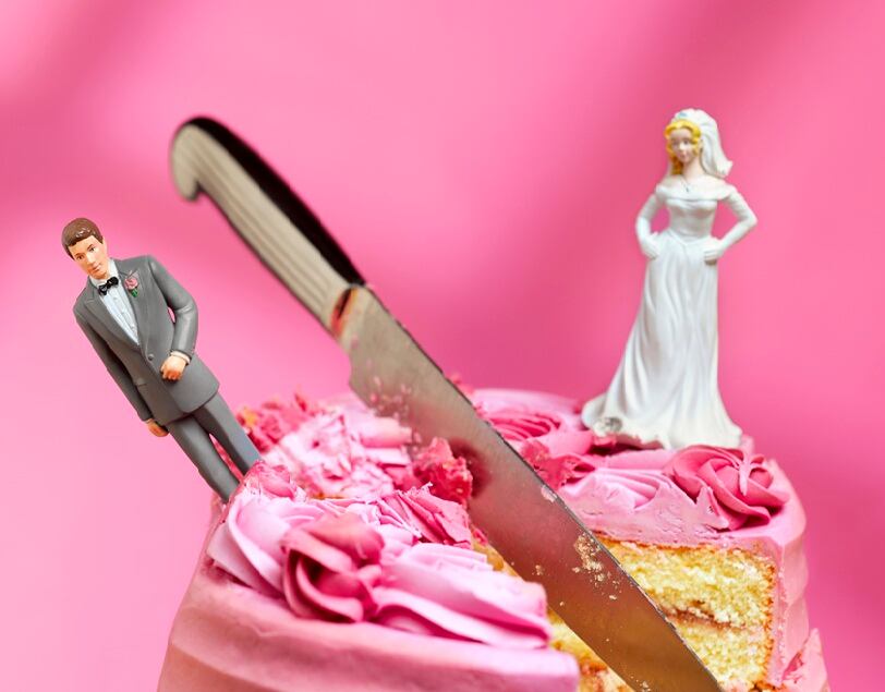 knife cutting between bride and groom figurines, relationship breakup