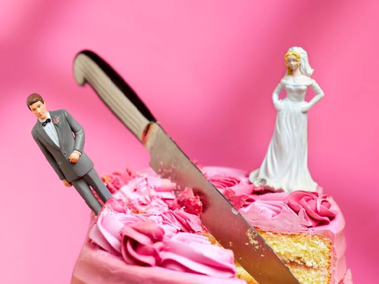 knife cutting between bride and groom figurines, relationship breakup