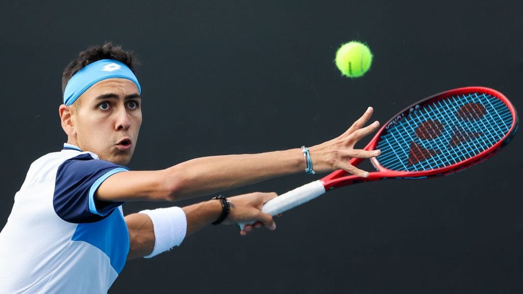 Chile's Alejandro Tabilo hits a return against John Isner of the US during their men's singles match on day four of the Australian Open tennis tournament in Melbourne on January 23, 2020. (Photo by DAVID GRAY / AFP) / IMAGE RESTRICTED TO EDITORIAL USE - STRICTLY NO COMMERCIAL USE (Photo by DAVID GRAY/AFP via Getty Images)