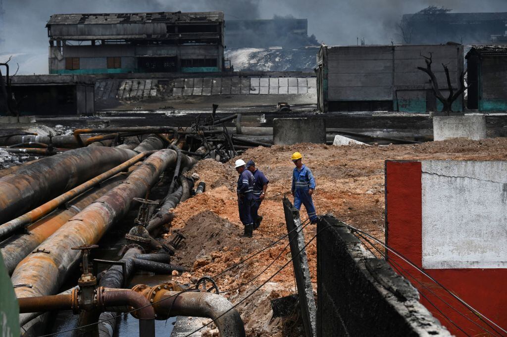 Trabajadores revisan el daño del incendio en tanques de crudo en Cuba