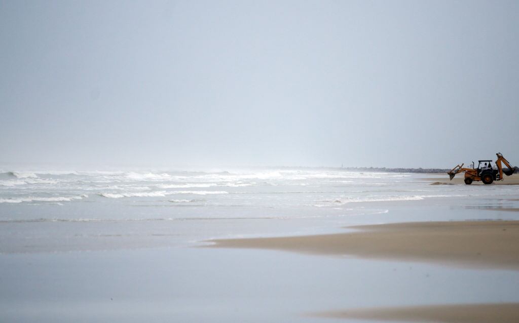 Una excavadora trabaja en la limpieza de una playa en la costa del estado de Tamaulipas en México ante la llegada del ciclón.
