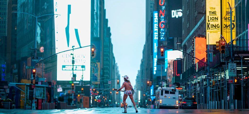 Street performer Robert John Burck, known as The Naked Cowboy, plays guitar amid coronavirus concern in the almost deserted Times Square on April 13, 2020 in New York City. - New York's governor declared April 13, 2020 that the "worst is over" for its coronavirus outbreak providing the state moves sensibly, despite reporting its death toll had passed 10,000. Andrew Cuomo said lower average hospitalization rates and intubations suggested a "plateauing" of the epidemic and that he was working on a plan to gradually reopen the economy. (Photo by Johannes EISELE / AFP) (Photo by JOHANNES EISELE/AFP via Getty Images)