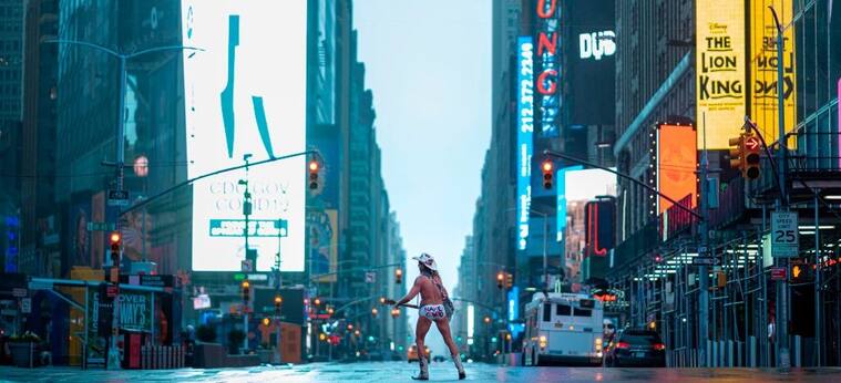 Street performer Robert John Burck, known as The Naked Cowboy, plays guitar amid coronavirus concern in the almost deserted Times Square on April 13, 2020 in New York City. - New York's governor declared April 13, 2020 that the "worst is over" for its coronavirus outbreak providing the state moves sensibly, despite reporting its death toll had passed 10,000. Andrew Cuomo said lower average hospitalization rates and intubations suggested a "plateauing" of the epidemic and that he was working on a plan to gradually reopen the economy. (Photo by Johannes EISELE / AFP) (Photo by JOHANNES EISELE/AFP via Getty Images)