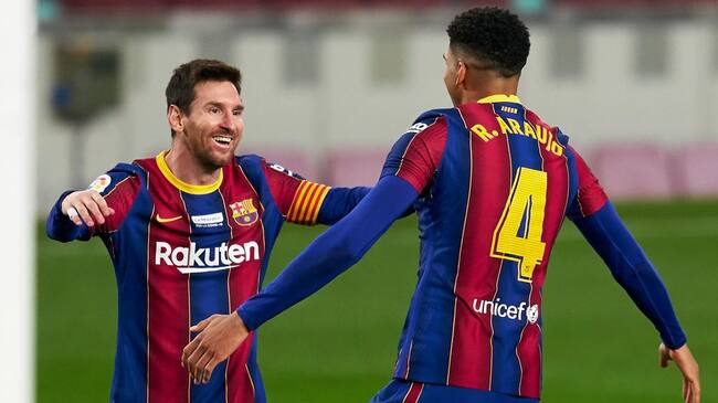 BARCELONA, SPAIN - DECEMBER 19: Ronald Araujo of FC Barcelona celebrates after scoring his team's second goal with his teammate Lionel Messi during the La Liga Santander match between FC Barcelona and Valencia CF at Camp Nou on December 19, 2020 in Barcelona, Spain. Sporting stadiums around Spain remain under strict restrictions due to the Coronavirus Pandemic as Government social distancing laws prohibit fans inside venues resulting in games being played behind closed doors. (Photo by Pedro Salado/Quality Sport Images/Getty Images)