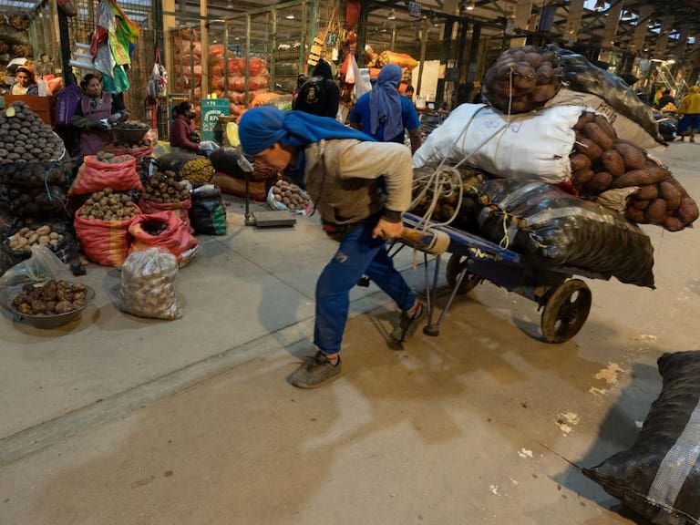 Un trabajador traslada sacos en el mercado Santa Anita de Lima en Perú