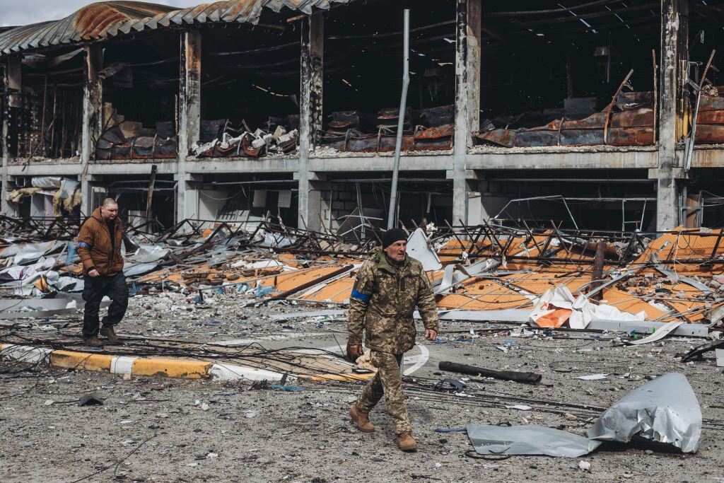 Militares ucranianos caminan ante un edificio destruido cerca de Kiev