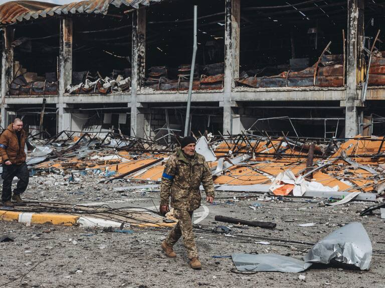 Militares ucranianos caminan ante un edificio destruido cerca de Kiev