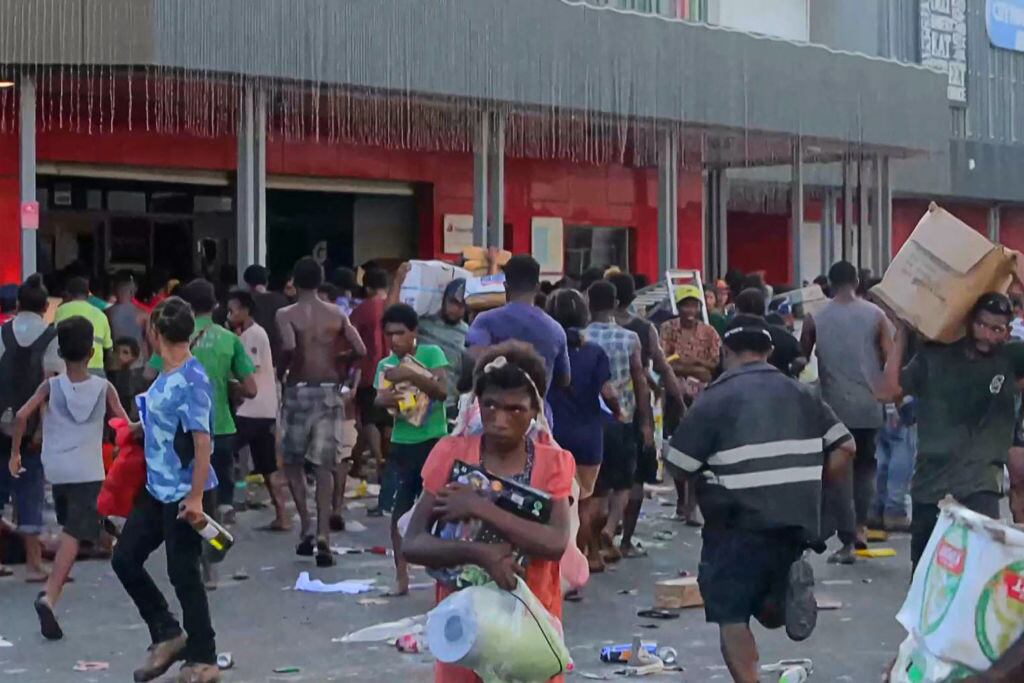 Las personas saquean una tienda en Puerto Moresby, en medio de la protesta de policías, soldados y gendarmes en Papúa Nueva Guinea.