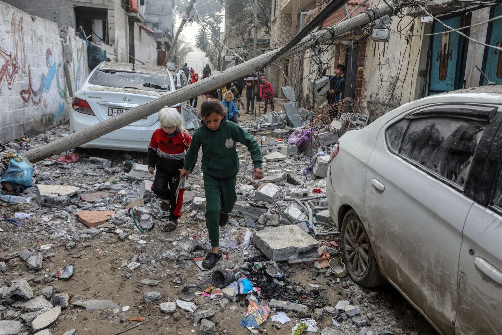 Dos niños corren entre escombros y en medio de los ataques aéreos de Israel sobre la zona de Rafah, en el sur de la Franja de Gaza en Palestina.