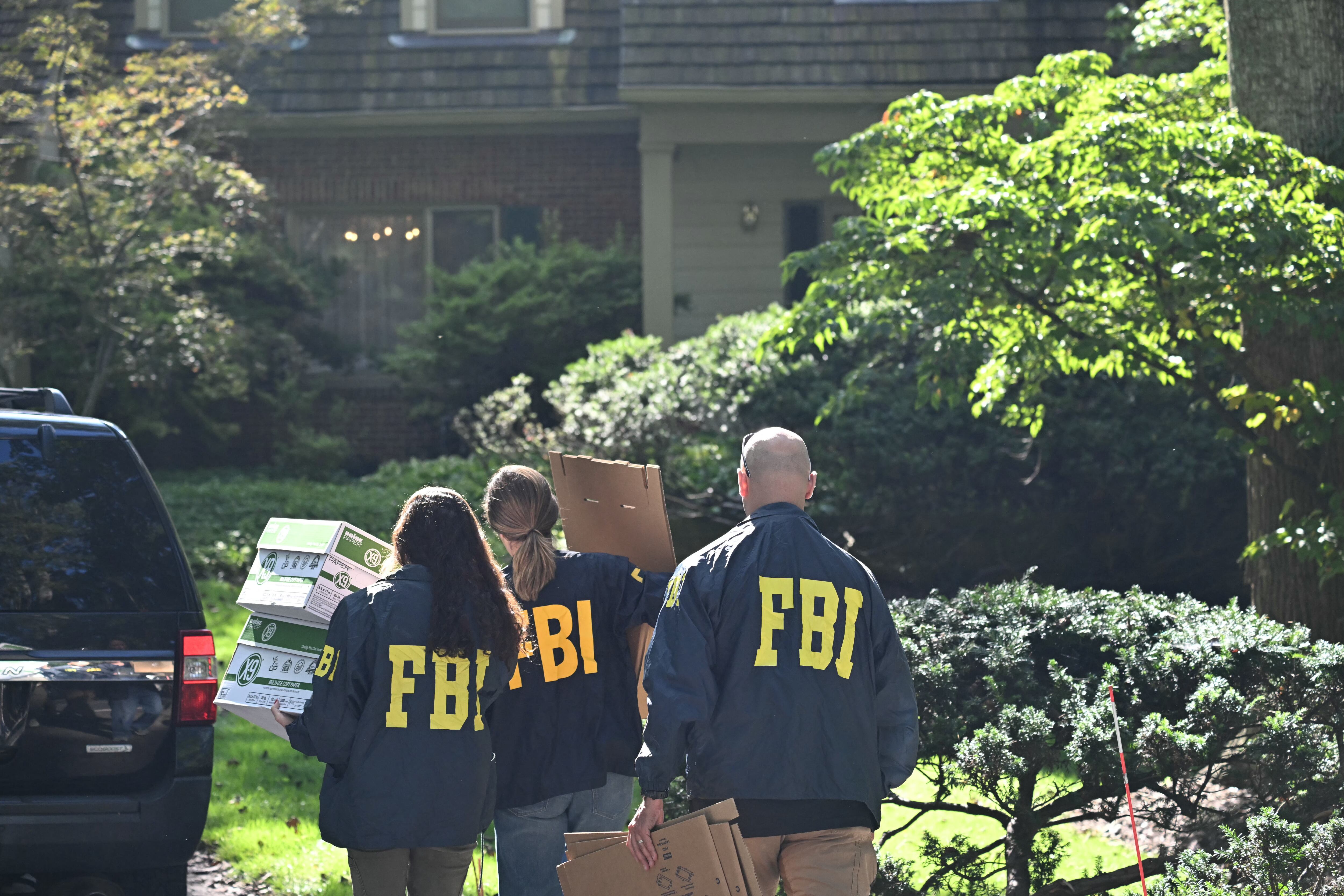 TOPSHOT - FBI agents carry boxes as they arrive at John Bolton's house, Donald Trump's former national security advisor after the FBI conducted a court-authorized search at his place on August 22, 2025 in Bethesda, Maryland. Federal Bureau of Investigation agents searched on Friday the home of John Bolton, Donald Trump's former national security advisor who has become a vocal critic of the US president. (Photo by SAUL LOEB / AFP) (Photo by SAUL LOEB/AFP via Getty Images)          