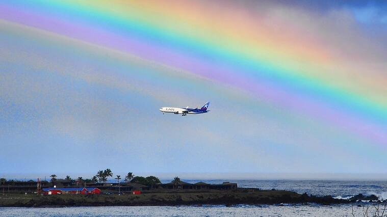 A plane is seen next to the rainbow on Ankaroa bay in Easter Island, 3700 km off the Chilean coast in the Pacific Ocean, on July 12, 2010. AFP PHOTO/Martin Bernetti (Photo credit should read MARTIN BERNETTI/AFP via Getty Images)