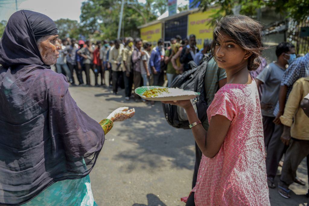 Personas en situación de calle reciben alimentos durante la cuarentena la ciudad india de Hyderabad
