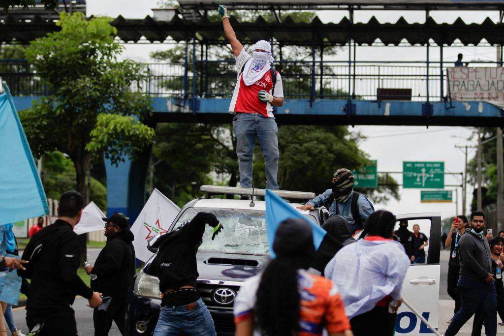 Manifestantes sobre un auto policial en las protestas en Panamá