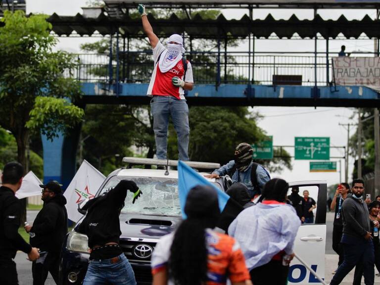 Manifestantes sobre un auto policial en las protestas en Panamá
