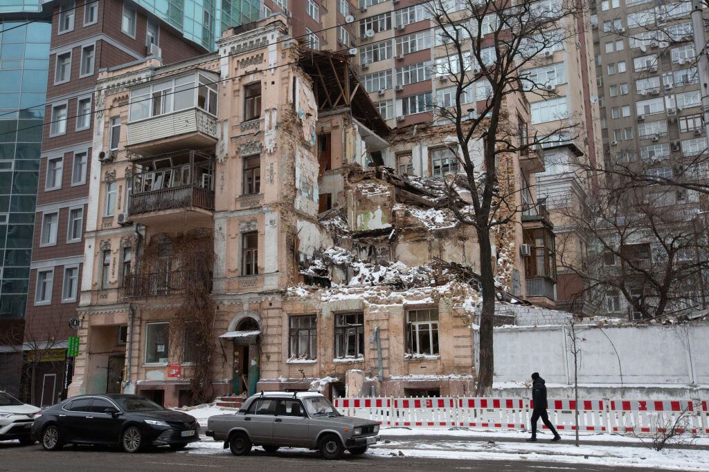 Un hombre camina ante un edificio en ruinas por impacto de misiles en Kiev de Ucrania