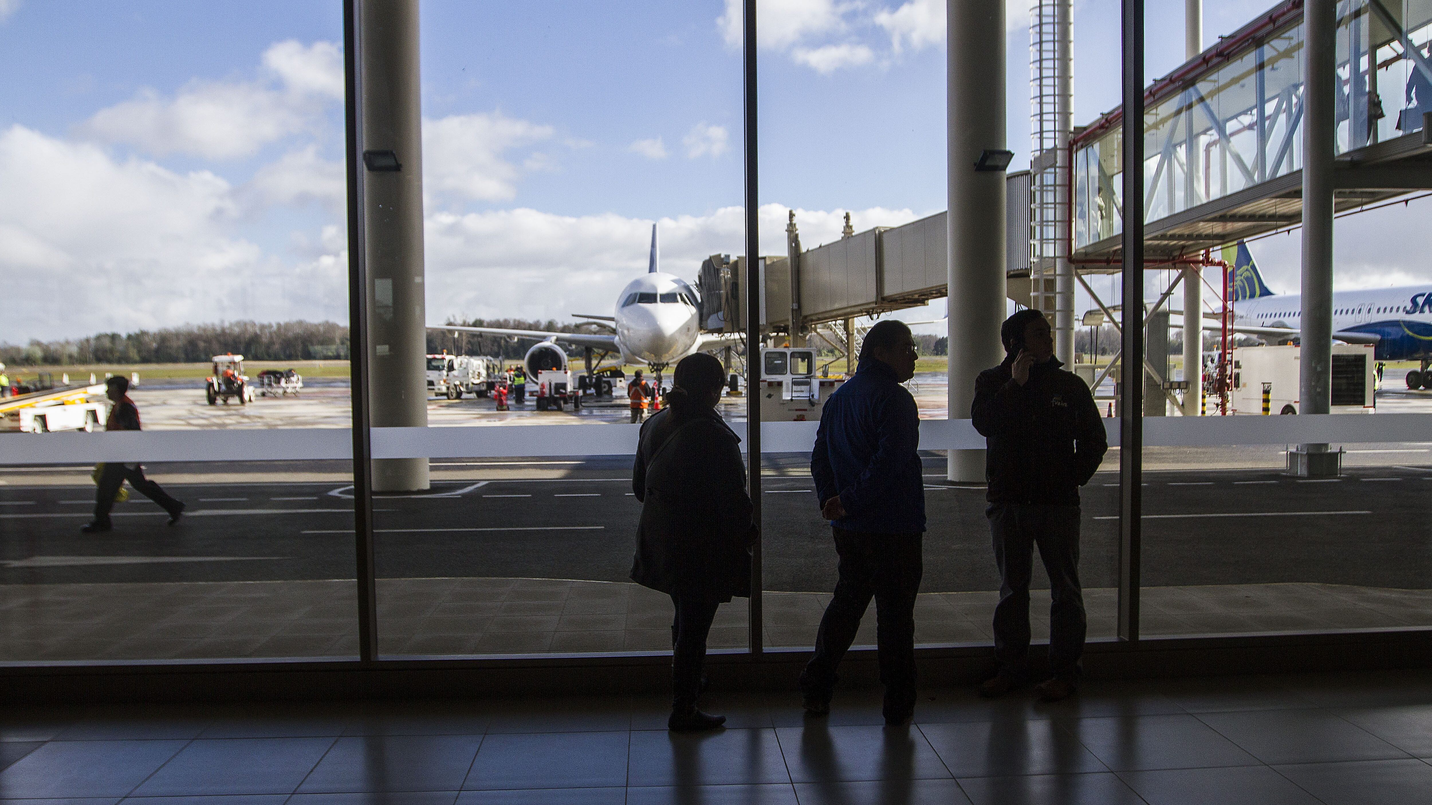29 Julio de 2014/FREIRE Con el aterrizaje del primer vuelo comercial entró en funciones esta tarde el aeropuerto regional de La Araucanía en la localidad de Quepe, 20 kilómetros al sur de Temuco. En la imagen, tres personas conversan observando el aterrizaje de un avión
FOTO:DAVID CORTES SEREY/AGENCIAUNO