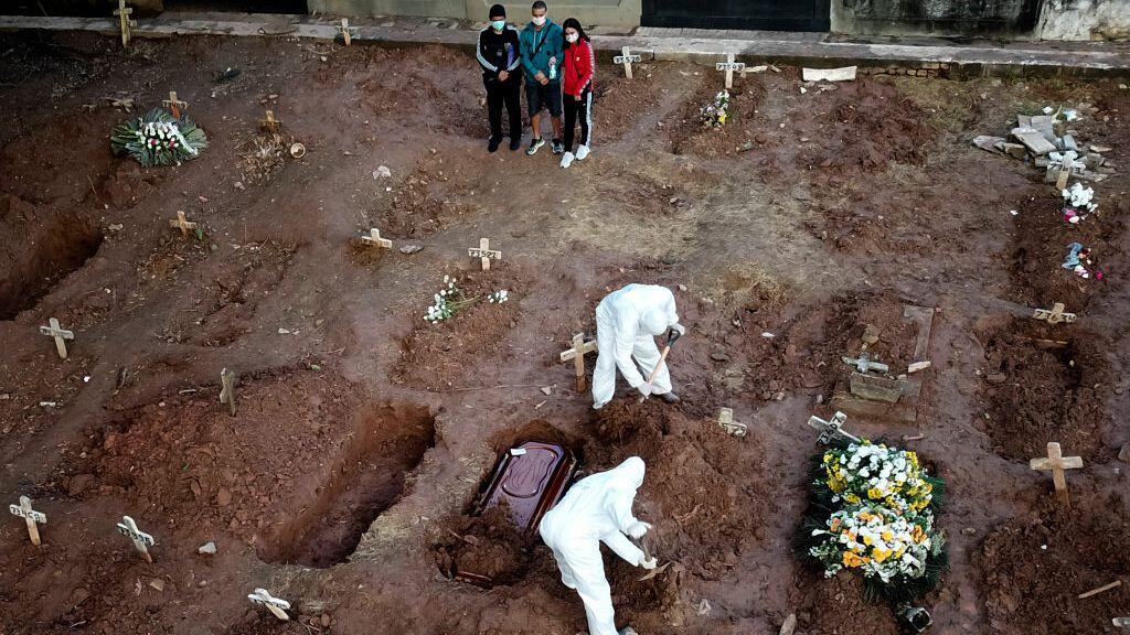 RIO DE JANEIRO, BRAZIL - MAY 08: Relatives of Neide Rodrigues, 71, who died of the coronavirus disease (COVID-19), mourn at the Caju cemetery on May 8, 2020 in Rio de Janeiro, Brazil. According to the Brazilian Health Ministry, Brazil has 135.106 positive cases of coronavirus (COVID-19) and a total of 9.146  deaths. (Photo by Buda Mendes/Getty Images)