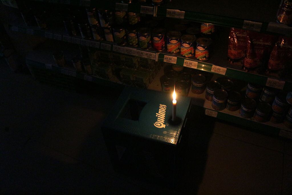 Una vela ilumina un pequeño mercado en la ciudad de Buenos Aires