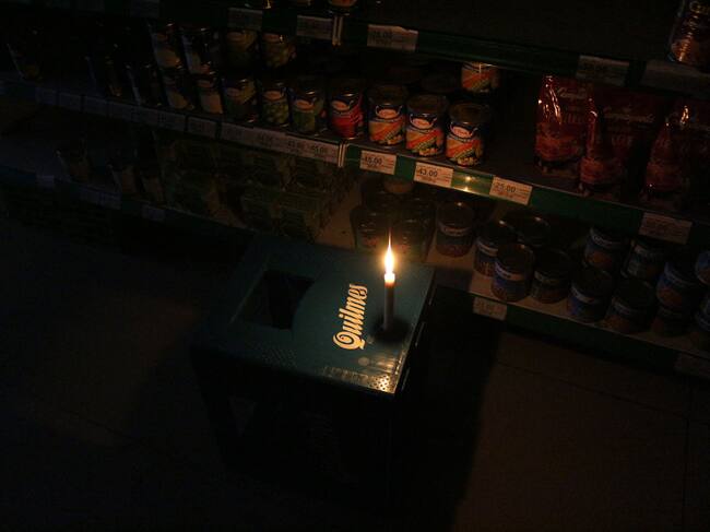 Una vela ilumina un pequeño mercado en la ciudad de Buenos Aires
