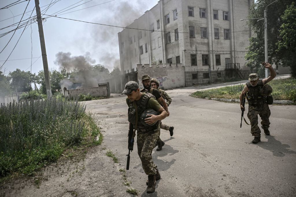 Militares ucranianos corren a cubrirse ante los tiros de artillería rusos