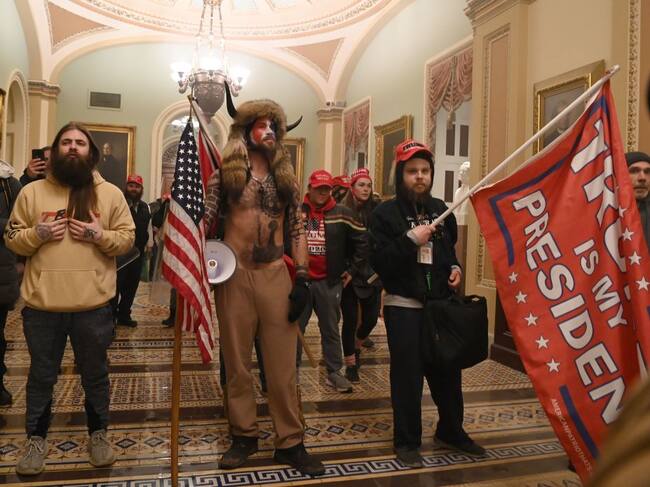 Chansley junto a un grupo de fanáticos de Trump en los pasillos del Capitolio