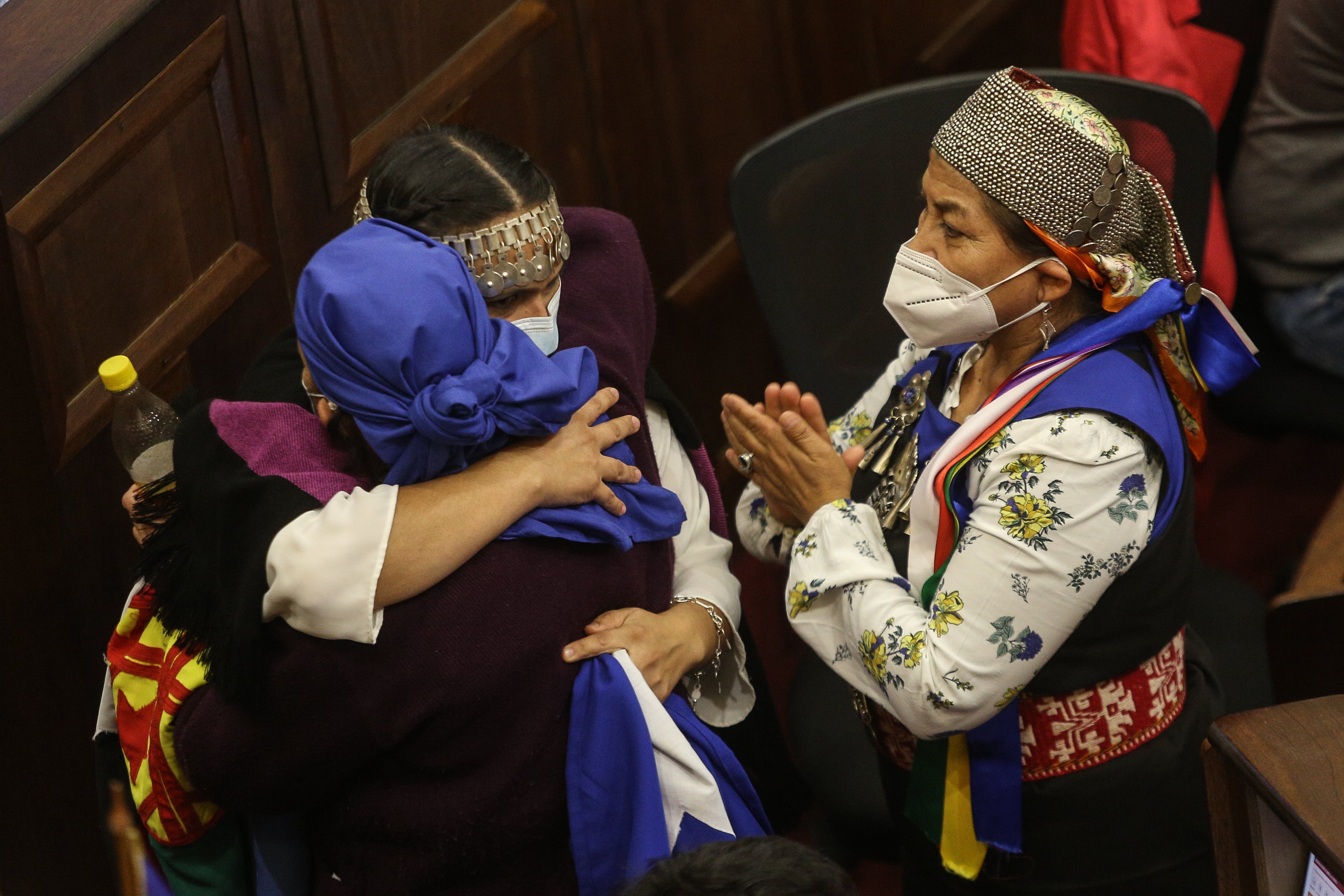 La convencional Francisca Linconao, abraza a la convencional Rosa Catrileo junto a Elisa Loncón durante la Sesión N°95 Pleno Convención Constitucional, que se realiza en el ex congreso Nacional. FOTO: DIEGO MARTIN/AGENCIAUNO