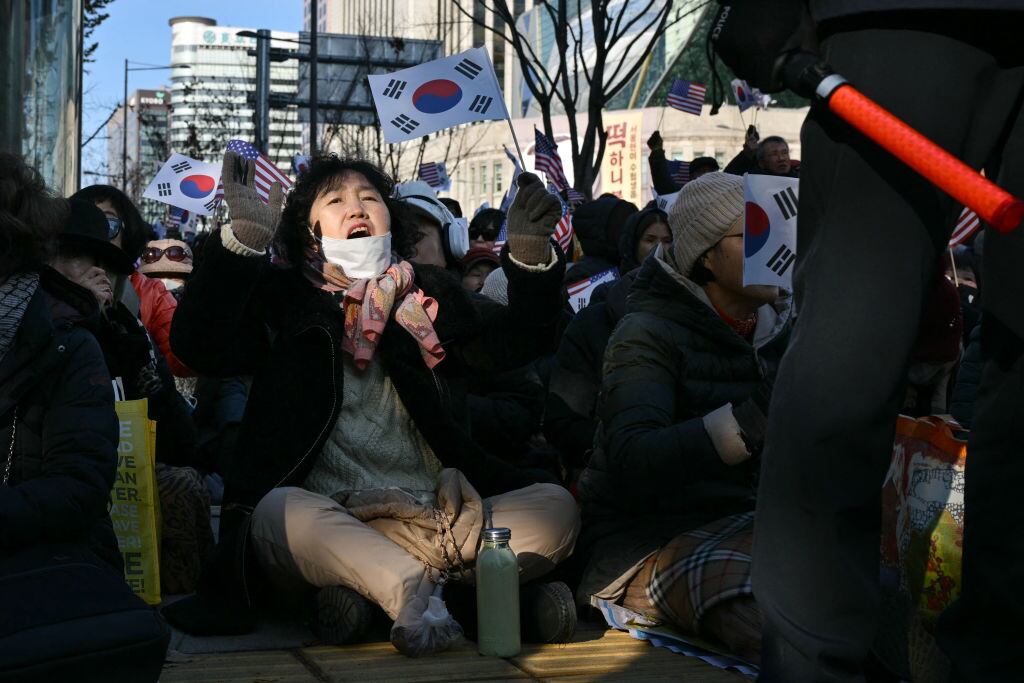Personas en la ciudad de Seúl realizan una protesta sentados en contra de la ley marcial que había aplicado el presiente de Corea del Sur