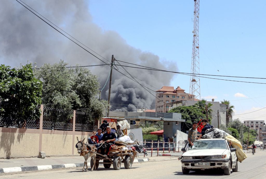 El humo se levanta luego de un ataque aéreo contra Rafah, mientras una familia palestina intenta huir de esa zona en la Franja de Gaza.