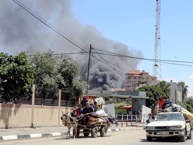 El humo se levanta luego de un ataque aéreo contra Rafah, mientras una familia palestina intenta huir de esa zona en la Franja de Gaza.