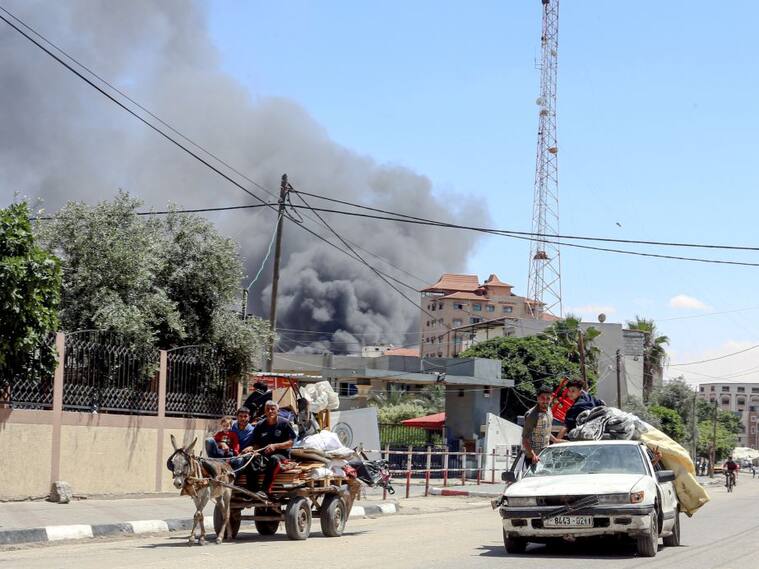 El humo se levanta luego de un ataque aéreo contra Rafah, mientras una familia palestina intenta huir de esa zona en la Franja de Gaza.
