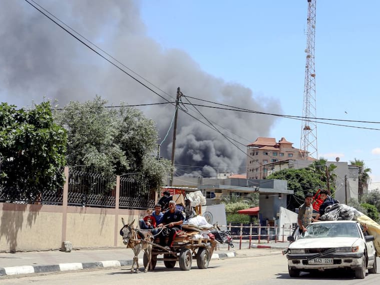 El humo se levanta luego de un ataque aéreo contra Rafah, mientras una familia palestina intenta huir de esa zona en la Franja de Gaza.