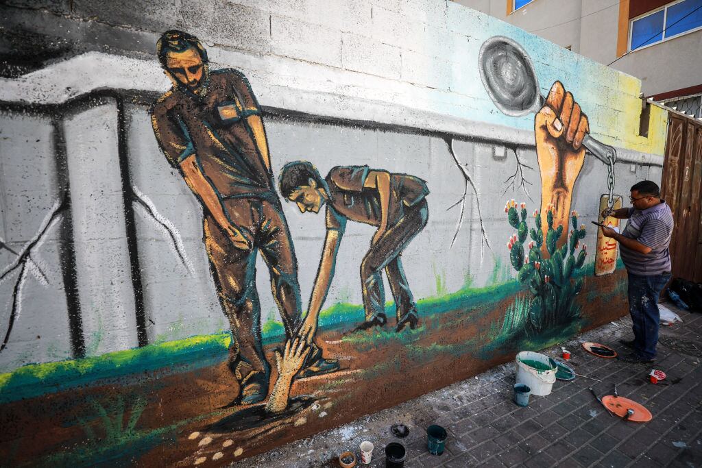 Artista pinta un mural en Gaza de la fuga de prisioneros palestinos