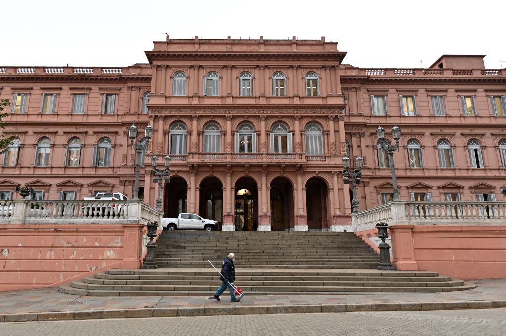 Hombre camina ante la Casa Rosada, la sede del gobierno de Argentina