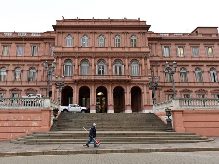 Hombre camina ante la Casa Rosada, la sede del gobierno de Argentina