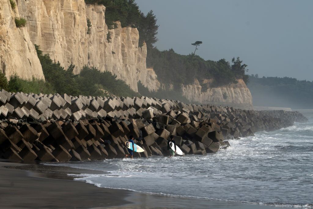 Personas practican surf en el mar japonés