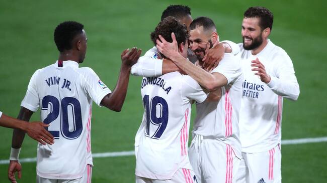 CADIZ, SPAIN - APRIL 21: Alvaro Odriozola of Real Madrid celebrates with Karim Benzema after scoring their side's second goal during the La Liga Santander match between Cadiz CF and Real Madrid at Estadio Ramon de Carranza on April 21, 2021 in Cadiz, Spain. Sporting stadiums around Spain remain under strict restrictions due to the Coronavirus Pandemic as Government social distancing laws prohibit fans inside venues resulting in games being played behind closed doors. (Photo by Fran Santiago/Getty Images)
