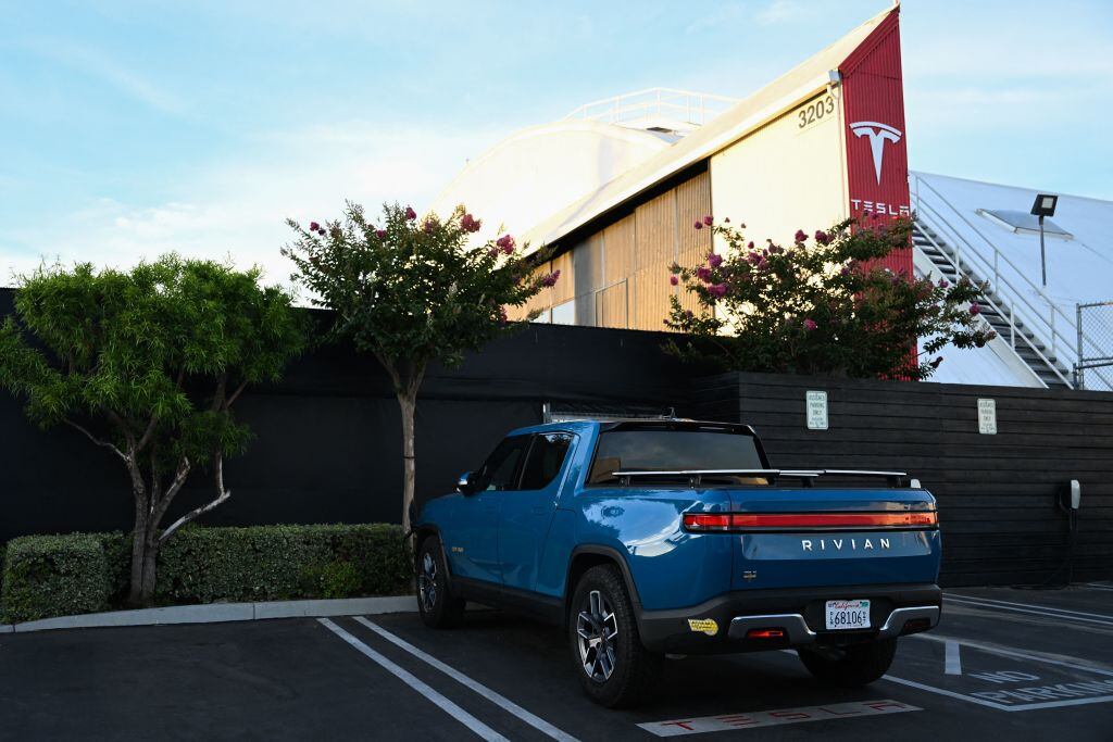 Una camioneta eléctrica estacionada afuera de la sede de la empresa Tesla