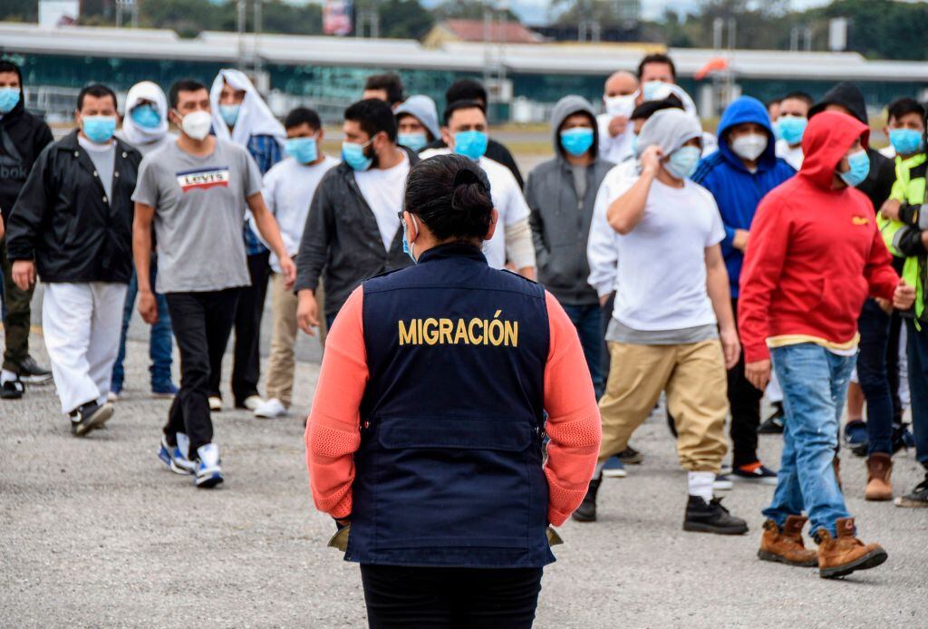 Funcionaria observa un grupo de migrantes en Guatemala
