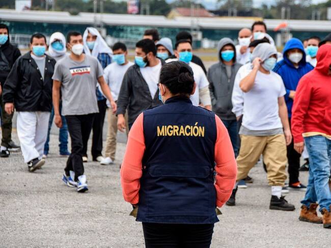 Funcionaria observa un grupo de migrantes en Guatemala