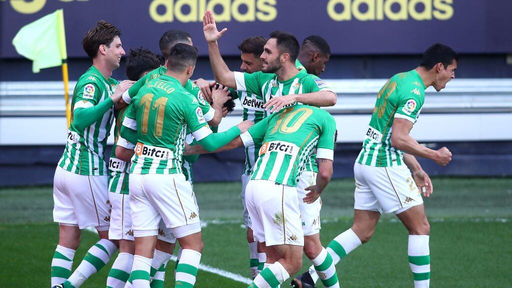 CADIZ, SPAIN - FEBRUARY 28: Juanmi of Real Betis celebrates with team mates after scoring their side's first goal during the La Liga Santander match between Cadiz CF and Real Betis at Estadio Ramon de Carranza on February 28, 2021 in Cadiz, Spain. Sporting stadiums around Spain remain under strict restrictions due to the Coronavirus Pandemic as Government social distancing laws prohibit fans inside venues resulting in games being played behind closed doors. (Photo by Fran Santiago/Getty Images)
