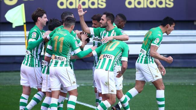 CADIZ, SPAIN - FEBRUARY 28: Juanmi of Real Betis celebrates with team mates after scoring their side's first goal during the La Liga Santander match between Cadiz CF and Real Betis at Estadio Ramon de Carranza on February 28, 2021 in Cadiz, Spain. Sporting stadiums around Spain remain under strict restrictions due to the Coronavirus Pandemic as Government social distancing laws prohibit fans inside venues resulting in games being played behind closed doors. (Photo by Fran Santiago/Getty Images)