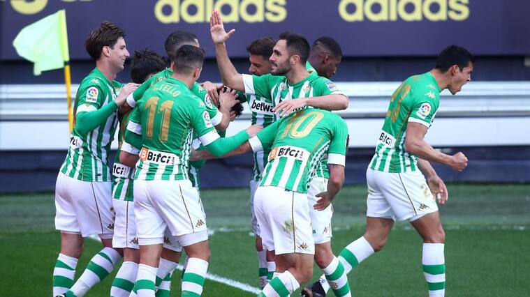 CADIZ, SPAIN - FEBRUARY 28: Juanmi of Real Betis celebrates with team mates after scoring their side's first goal during the La Liga Santander match between Cadiz CF and Real Betis at Estadio Ramon de Carranza on February 28, 2021 in Cadiz, Spain. Sporting stadiums around Spain remain under strict restrictions due to the Coronavirus Pandemic as Government social distancing laws prohibit fans inside venues resulting in games being played behind closed doors. (Photo by Fran Santiago/Getty Images)