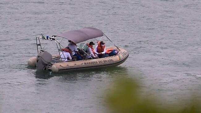 Brazil's Navy officers are seen during a rescue operation at the Furnas Lake in Capitolio, Minas Gerais State, Brazil, on January 9, 2022, a day after a large rock fragment broke off a ravine and plunged onto several tourist boats leaving at least eight people dead at the nearby canyons of Furnas Lake. - At least eight people were killed and three were missing as rescue teams including a dive squad and members of the Brazilian Navy rushed to Furnas Lake to search for victims, a day after panicked tourists had watched helplessly as a large rock fragment broke off a ravine and plunged atop three boats. (Photo by Douglas MAGNO / AFP) (Photo by DOUGLAS MAGNO/AFP via Getty Images)