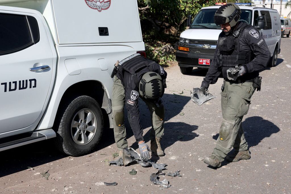 Policías de Israel revisan los restos de un cohete lanzado por Hezbolá que impactó en los alrededores de la ciudad de Tel Aviv