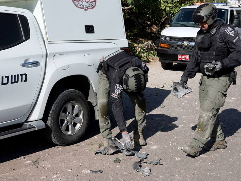 Policías de Israel revisan los restos de un cohete lanzado por Hezbolá que impactó en los alrededores de la ciudad de Tel Aviv