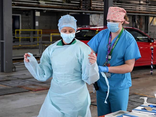Unas trabajadoras de la salud se colocan ropa de seguridad en un hospital de Irlanda